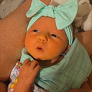 Aurora is registered to the contest to win money with this photo: baby, infant, headband, bow, clothing, unicorn, colorful, blanket, legs, socks, person, hand, skin, cute, lying, fabric, pattern, indoors, cozy, soft
