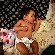 Jeremiah is registered to the contest to win money with this photo: baby, sleeping, diaper, plush_toy, blanket, pillow, pattern, cute, child, infant, peaceful, resting, soft_toy, nursery, lying_down, skin, indoors, comfort, relaxation, toddler