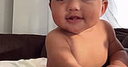 Jeremiah joined the competition — help win amazing prizes! baby, child, diaper, smile, indoor, curtain, person, lap, hand, face, skin, sitting, couch, window, light, room, social_media, screenshot, text_overlay, portrait