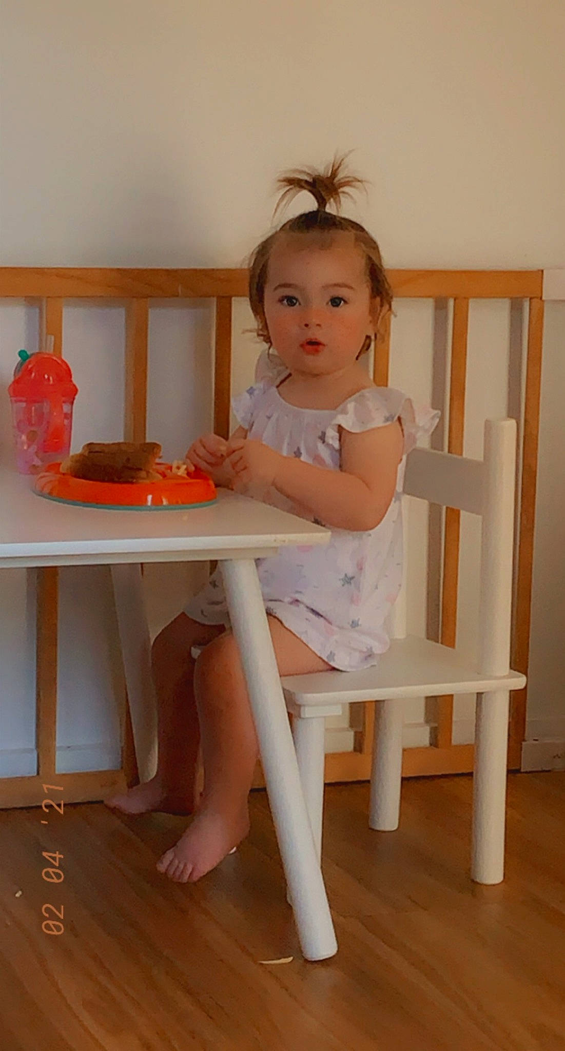 Ava Jane is registered to the contest to win money with this photo: baby_toddler_clothing, chair, child, comfort, flooring, foot, furniture, hair, hardwood, human_leg, knee, peach, person, pink, sitting, skin, table, tableware, thigh, toddler