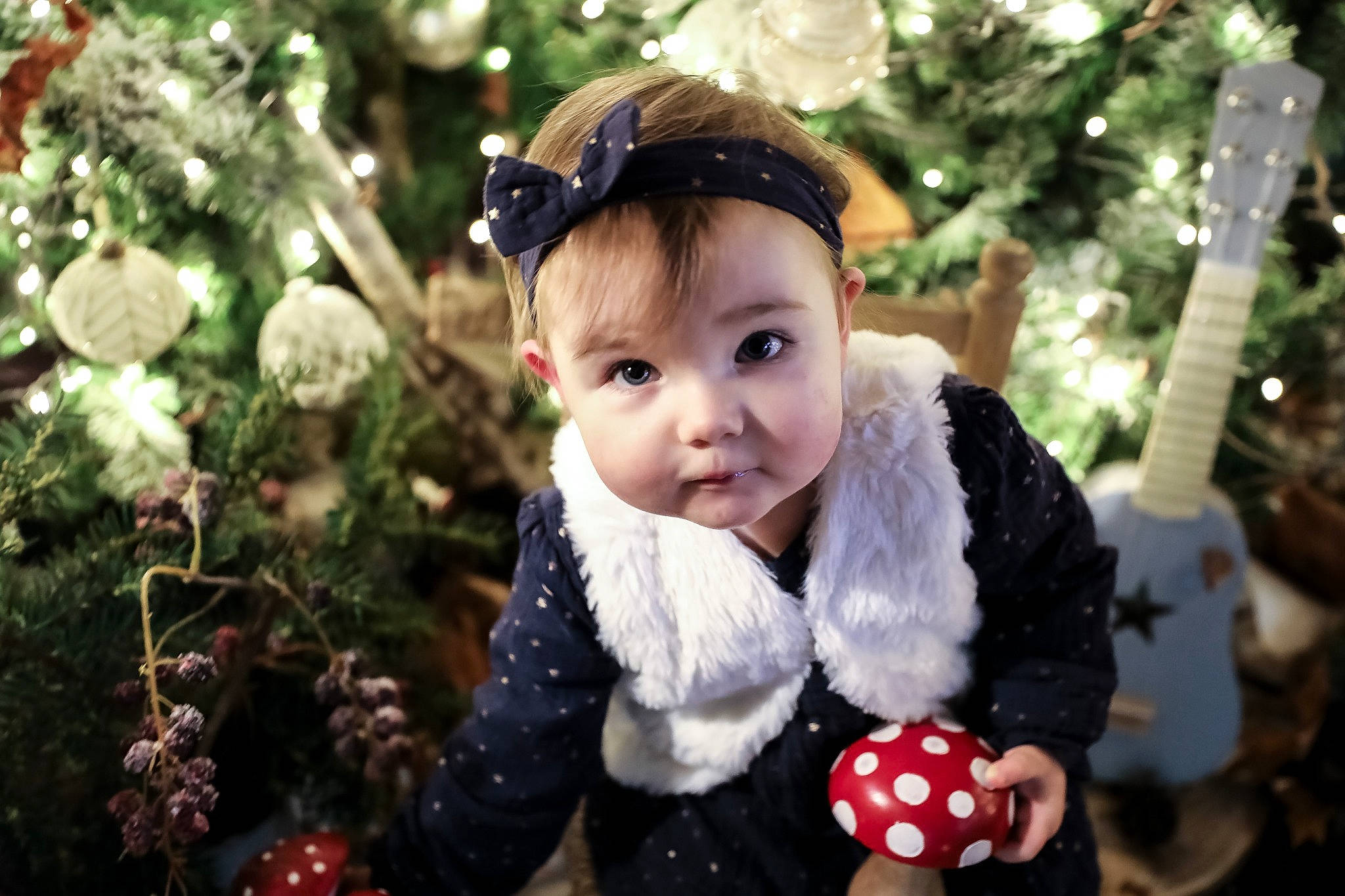 Lysa participe au concours pour gagner de l'argent avec cette photo : baby, baby_toddler_clothing, christmas, christmas_decoration, christmas_ornament, christmas_tree, event, eye, facial_expression, fun, happy, head, holiday, holiday_ornament, ornament, people_in_nature, person, plant, toddler, tree
