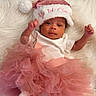 Kali Eve joined the competition — help win amazing prizes! baby, infant, pink_tutu, santa_hat, festive, holiday, cute, soft_texture, white_background, newborn, clothing, portrait, smiling, happy, furry, closeup, celebration, adorable, lying_down, child