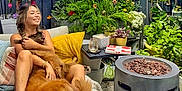 Effy is registered to the contest to win money with this photo: woman, dog, outdoor, garden, plants, flowers, fence, patio, sofa, blanket, pillow, fire_pit, sign, planter, succulent, side_table, drink, box, barefoot, bone_toy