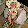 baby, sleeping, cushion, pillow, toy, overalls, car_print, mittens, infant, indoor, carpet, child, cute, soft, comfort, relaxing, seated, clothing, fabric, nap