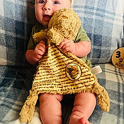 Waylon joined the competition — help win amazing prizes! baby, infant, plush_toy, winnie_the_pooh, blue_eyes, blanket, plaid, milestone, wooden_plaque, sitting, cute, soft_toy, child, smiling, indoors, cozy, clothing, feet, hands, portrait