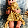 baby, infant, plush_toy, winnie_the_pooh, blue_eyes, blanket, plaid, milestone, wooden_plaque, sitting, cute, soft_toy, child, smiling, indoors, cozy, clothing, feet, hands, portrait