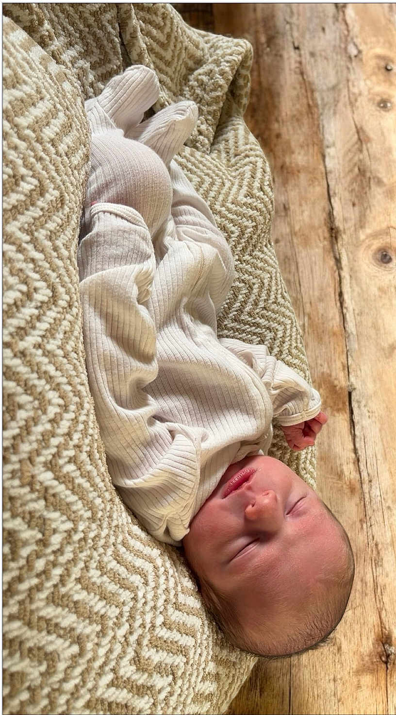 Waylon joined the competition — help win amazing prizes! baby, newborn, sleeping, infant, blanket, ribbed_clothing, cozy, peaceful, soft_texture, wooden_floor, closeup, portrait, child, cute, resting, indoors, natural_light, warm_colors, tiny_hands, relaxation