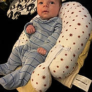 Asher is registered to the contest to win money with this photo: baby, infant, onesie, blue_stripes, pillow, pattern, sun_design, fist, face, eyes, head, comfort, sleepwear, soft, closeup, indoor, cute, newborn, person, resting