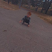 Noah joined the competition — help win amazing prizes! child, toddler, red_hair, road, trees, outdoor, nature, park, crouching, smiling, casual_clothing, daytime, asphalt, lamp_post, grass, fence, happy, playful, young, person
