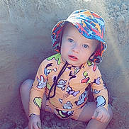 Noah joined the competition — help win amazing prizes! beach, bucket_hat, child, colorful_clothing, cute, expression, eyes, face, hands, nature, outdoor, play, recreation, sand, sitting, summer, sunlight, swimsuit, toddler, vacation
