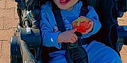 Oceanna joined the competition — help win amazing prizes! apple, baby, blue_clothing, casual, child, cute, daytime, happy, outdoor, pavement, person, playful, seatbelt, shoes, sitting, smiling, stroller, sunlight, toddler, young_child