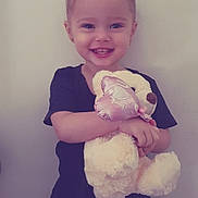 Oceanna joined the competition — help win amazing prizes! black_shirt, casual_clothing, child, cute, earrings, girl, hair_buns, happy, holding, indoor, light_background, person, plush_toy, portrait, small_ears, smile, standing, teddy_bear, toy, young_child