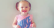 Oceanna is registered to the contest to win money with this photo: casual_clothing, child, cute, floor, girl, happy, heart_pattern, indoor, lollipop, nike, person, pigtails, pink, shorts, smiling, standing, toddler, tshirt, wall, white_sneakers