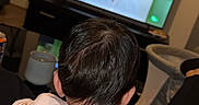 Ayla is registered to the contest to win money with this photo: child, toddler, baby, back_view, sitting, television, watching_tv, living_room, indoor, home, adult_hand, support, short_hair, pink_shirt, furniture, floor_lamp, wall_clock, cozy, entertainment, family