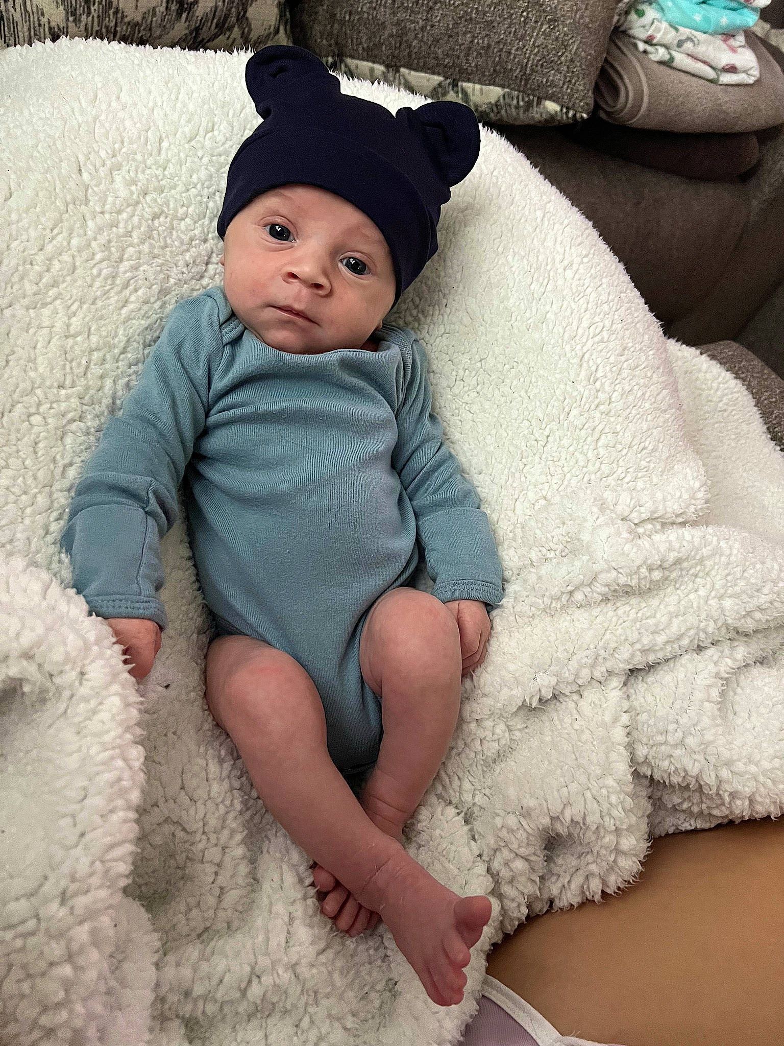 Gianni is registered to the contest to win money with this photo: baby, baby_toddler_clothing, cap, comfort, costume_hat, fashion_accessory, headgear, headwear, human_leg, knit_cap, linens, pattern, person, pink, sitting, skin, sleeve, sun_hat, textile, thigh