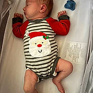 Macayla is registered to the contest to win money with this photo: newborn, baby, sleeping, crib, onesie, santa, holiday, pacifier, infant, clothing, bed, resting, cute, child, person, indoor, mesh_crib, soft_lighting, peaceful, wrapped