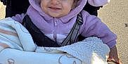 Elina a rejoint le concours — aidez-le/la à gagner de superbes lots ! baby, blanket, cartoon, character, child, cozy, cute, daylight, face, happy, hoodie, outdoor, person, portrait, purple, smiling, stroller, sunlight, toddler, warm_clothing