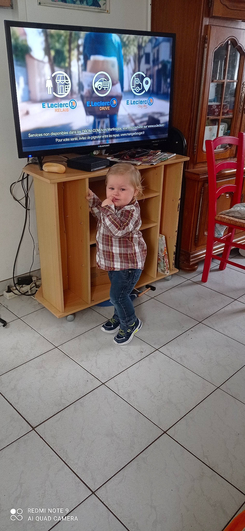Gabriel participe au concours pour gagner de l'argent avec cette photo : audio_equipment, chair, cleanliness, clothing, display_device, flat_panel_display, floor, flooring, hardwood, home_appliance, jeans, major_appliance, multimedia, person, shelf, standing, t_shirt, television, television_set, toddler