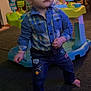 Brandon is registered to the contest to win money with this photo: toddler, child, indoor, carpet, barefoot, plaid_shirt, jeans, patches, baby_toys, activity_center, furniture, curious, standing, home, colorful, person, toy, floor, expression, young_child