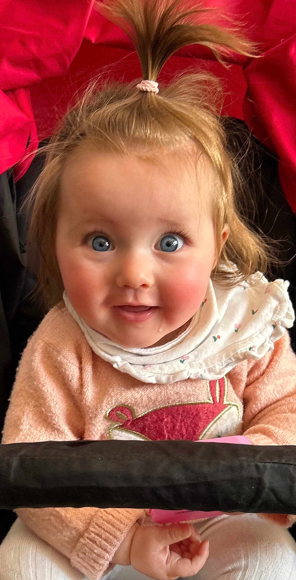 Cléo a rejoint le concours — aidez-le/la à gagner de superbes lots ! child, baby, infant, blue_eyes, rosy_cheeks, ponytail, hair_tie, bib, sweater, pink_clothing, stroller, seat, hands, toy, smile, portrait, close_up, cute, wide_eyes, soft_texture