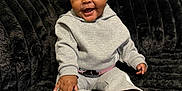 Kemora joined the competition — help win amazing prizes! baby, child, smiling, sitting, gray_outfit, pink_socks, black_couch, indoor, happy, cute, infant, footwear, hand, window_blinds, cozy, plush, portrait, face, person, young_child