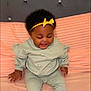 Kemora is registered to the contest to win money with this photo: baby, child, smiling, sitting, headband, yellow_bow, pastel_clothing, socks, bed, pink, blanket, soft, happy, cute, indoor, portrait, infant, person, home, cozy
