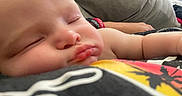 Max is registered to the contest to win money with this photo: baby, sleeping, close_up, face, cheeks, arm, skin, resting, person, indoors, comfort, peaceful, child, couch, blanket, casual, soft_light, relaxation, human, toddler