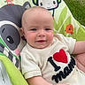 baby, smiling, infant, child, clothing, white_outfit, baby_seat, cute, face, portrait, indoors, colorful, animal_print, green, orange, red, happy, young_child, toddler, casual