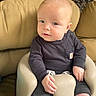 baby, child, infant, seat, cushion, clothing, long_sleeve, pants, sock, face, blue_eyes, light_hair, indoor, furniture, wicker, comfort, portrait, cute, sitting, casual