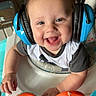 baby, headphones, smile, joyful, baby_walker, toy, music, indoor, child, happy, hair, blue, orange, white, clothing, seat, face, hand, play, infant