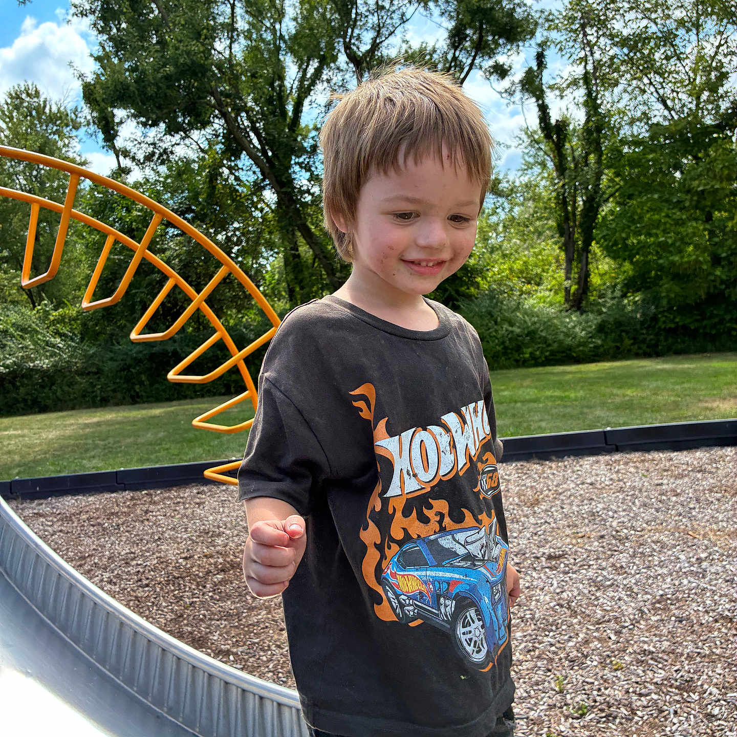 Uhtred is registered to the contest to win money with this photo: boy, casual_clothing, child, clouds, daytime, dirt, fun, grass, happy, hot_wheels, leisure, outdoor, playground, ripped_jeans, sky, slide, smiling, summer, trees, tshirt