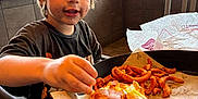 Uhtred is registered to the contest to win money with this photo: child, burger, curly_fries, food, meal, restaurant, table, tray, window, indoor, casual_dining, messy_face, young_boy, clothing, seat, hand, eating, cheese, lettuce, bread