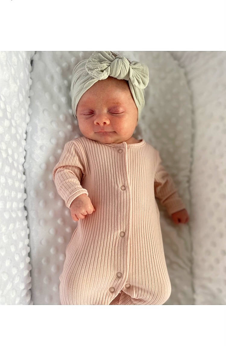 Jorgie is registered to the contest to win money with this photo: baby, baby_toddler_clothing, beige, cap, collar, face, fashion_accessory, headwear, jacket, knit_cap, linens, magenta, outerwear, pattern, peach, person, pink, product, sleeve, suit