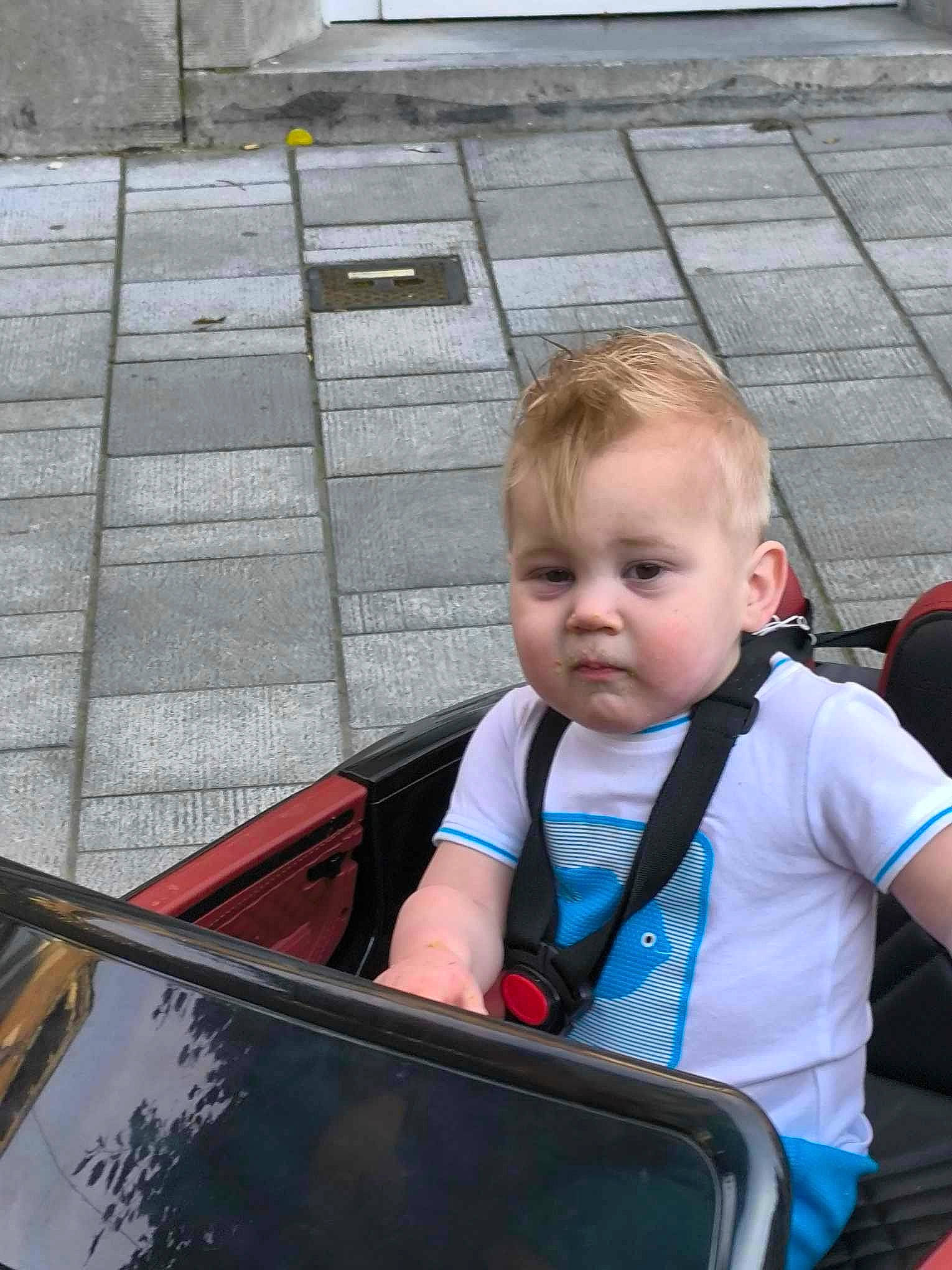 Tiyo a rejoint le concours — aidez-le/la à gagner de superbes lots ! automotive_exterior, automotive_window_part, baby, baby_carriage, baby_products, child, fun, grass, leisure, motor_vehicle, person, photograph, recreation, sitting, t_shirt, toddler, transport, travel, vacation, vehicle_door