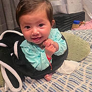 Anniliah is registered to the contest to win money with this photo: baby, child, smiling, blanket, bed, pillow, indoor, clothing, hands, face, person, happy, infant, cozy, pattern, furniture, home, cute, portrait, resting