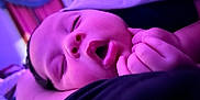 Adrin is registered to the contest to win money with this photo: baby, sleeping, close_up, face, hands, infant, purple_light, peaceful, cozy, portrait, soft_focus, indoor, newborn, cute, resting, child, skin, expression, calm, toddler