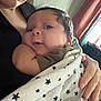 Adrin is registered to the contest to win money with this photo: baby, infant, blanket, stars, wrapped, adult, hand, holding, closeup, indoor, curious, face, skin, black_clothing, nail, window, curtain, light, cozy, comfort