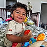 Krishiv joined the competition — help win amazing prizes! toddler, child, smiling, curly_hair, toy, bed, indoor, furniture, crib, plush_toy, happy, person, clothing, cute, baby, room, home, play, colorful, light