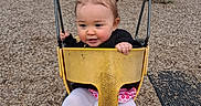 Zoë is registered to the contest to win money with this photo: toddler, child, swing, playground, yellow_swing, pink_booties, white_tights, black_jacket, hair_tie, outdoor, wood_chips, tree, park, fun, happy, play, person, daytime, clothing, seat