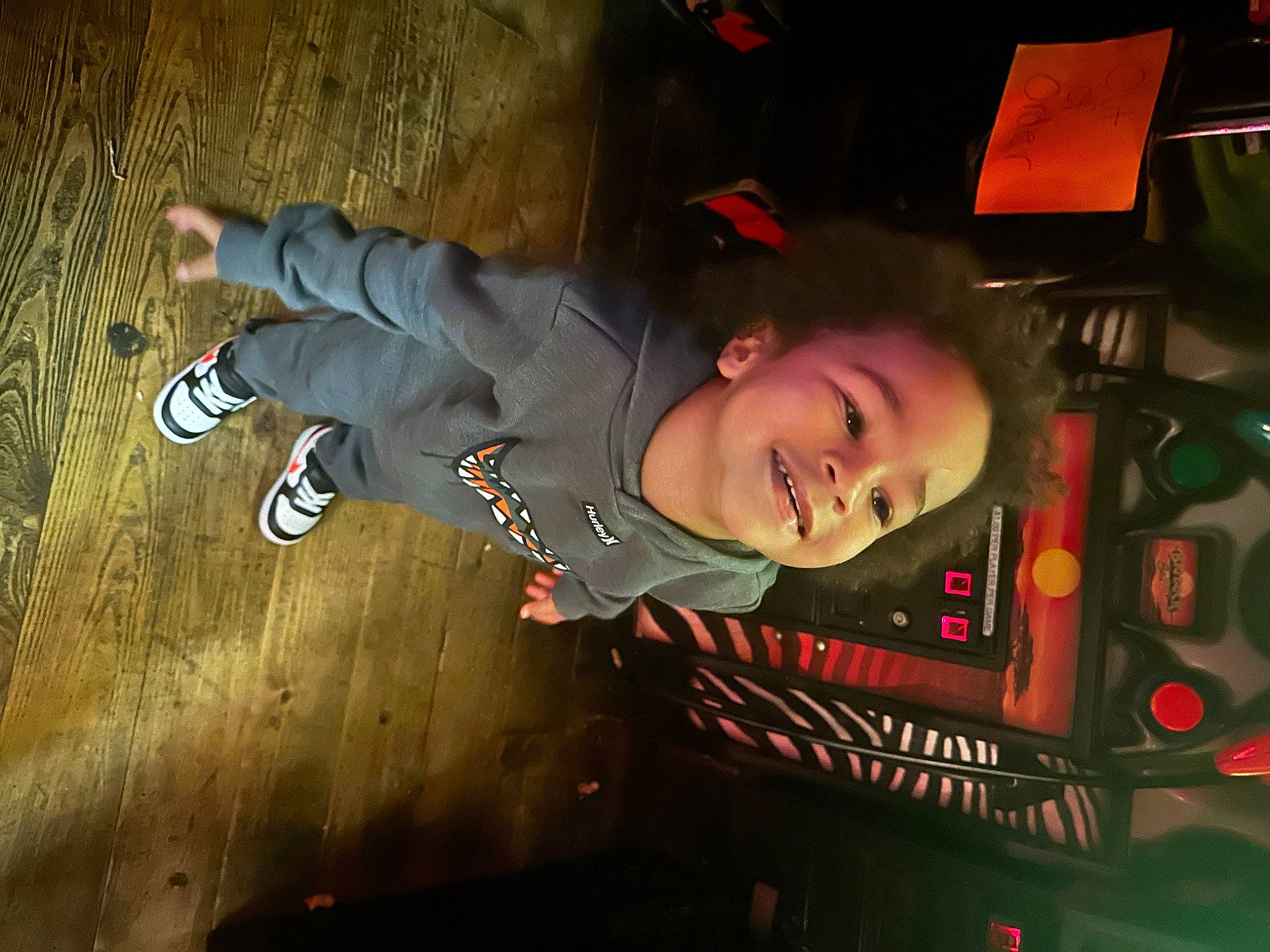 Levi is registered to the contest to win money with this photo: auto_part, automotive_exterior, automotive_lighting, automotive_tire, automotive_wheel_system, bumper, child, darkness, flash_photography, flooring, fun, helmet, joy, night, outdoor_shoe, person, recreation, room, smile, space