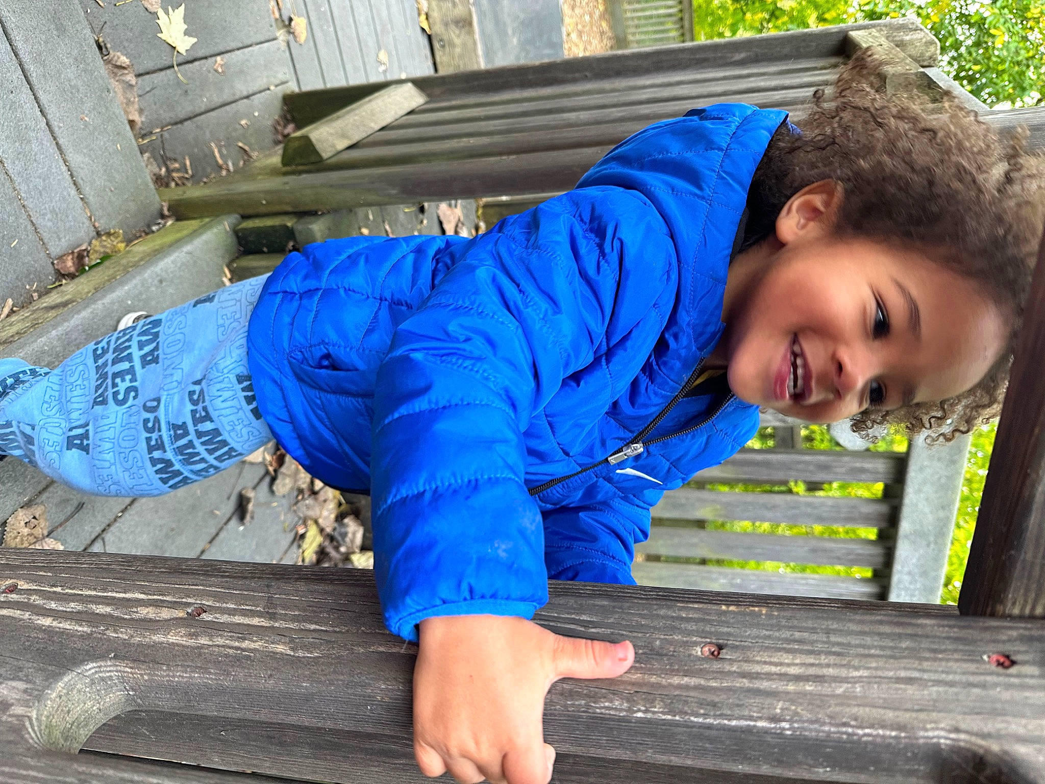 Levi is registered to the contest to win money with this photo: denim, electric_blue, flash_photography, fun, grass, happy, human_leg, joy, leisure, person, portrait_photography, sitting, sleeve, smile, soil, t_shirt, thigh, tree, waist, wood