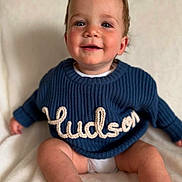 Hudson joined the competition — help win amazing prizes! baby, child, smiling, blue_sweater, knitted, name, hudson, sitting, blanket, soft, cute, portrait, happy, infant, indoors, clothing, warm, skin, face, eyes