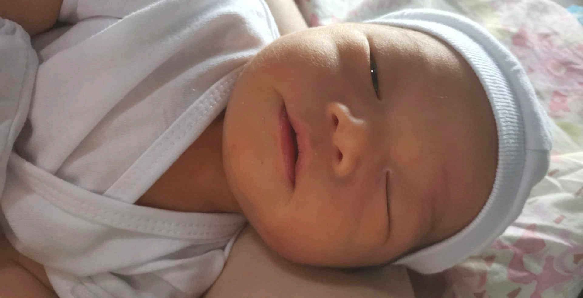 Kyler Lorenzo joined the competition — help win amazing prizes! baby, bed, blanket, cap, child, closeup, cute, face, headwear, indoors, infant, newborn, peaceful, portrait, resting, skin, sleeping, soft_light, white_clothing, young