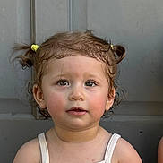 Luna participe au concours pour gagner de l'argent avec cette photo : toddler, child, face, portrait, pigtails, hair, yellow_hair_ties, tank_top, white_clothing, skin, eyes, expression, innocent, curious, person, young_child, closeup, indoors, background, soft_lighting