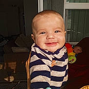 Leandro joined the competition — help win amazing prizes! baby, smile, striped_clothing, indoor, child, toy, hand, window, couch, light, face, person, happy, home, infant, portrait, holding, furniture, cozy, young_child