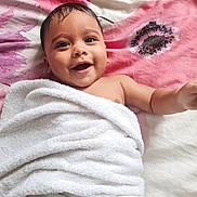 Jude participe au concours pour gagner de l'argent avec cette photo : baby, smiling, towel, blanket, happy, infant, face, skin, child, lying_down, cute, expression, indoors, portrait, young, person, comfort, soft_texture, head, arm