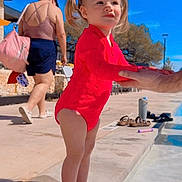Alessia joined the competition — help win amazing prizes! child, toddler, swimsuit, pool, water, pool_edge, standing, pigtails, sunny, outdoor, adult, hand, holding_hands, barefoot, feet, blue_sky, parent, vacation, sidewalk, flip_flops