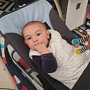 Adriel a rejoint le concours — aidez-le/la à gagner de superbes lots ! baby, infant, child, face, hand, baby_rocker, blanket, clothing, colorful_rug, toy, indoor, furniture, floor_tile, person, seated, cute, young_child, cuddly, cozy, playful