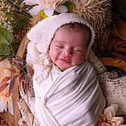 Miyla is registered to the contest to win money with this photo: baby, closeup, cozy, cute, decor, flowers, headwear, indoor, infant, natural_light, newborn, peaceful, portrait, sleeping, smiling, soft_fabric, warm, white_cloth, wooden_bowl, wrapped