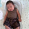 baby, infant, child, seat, cushion, bunny_print, brown_clothing, tank_top, shorts, patterned_clothing, relaxed, indoors, cute, young_child, portrait, person, skin, head, arms, legs